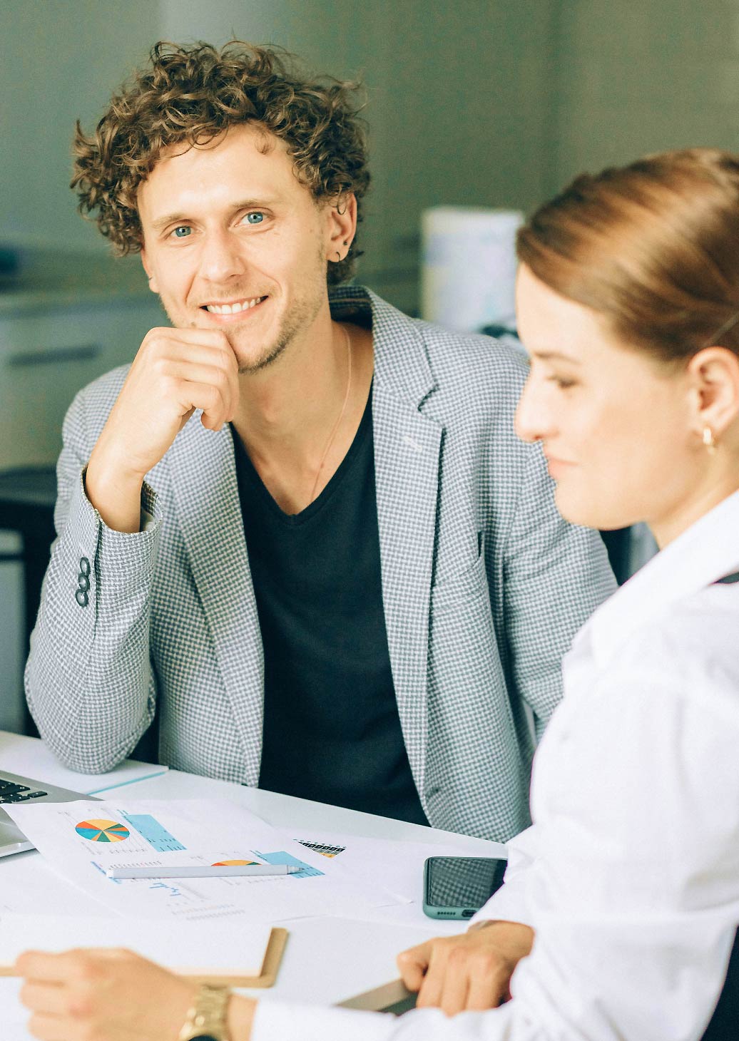 Zwei Personen sitzen vor Grafiken
